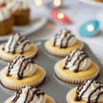 Tray of six mini peanut butter cheesecakes with whipped cream and chocolate drizzle.