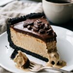 A close-up side view of a slice of coffee ice cream pie showing the thick filling and chocolate crust.