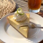A close-up side view of a slice of key lime pie showing the smooth creamy texture and graham cracker crust.