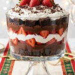 A close-up of a spoon lifting a scoop of chocolate trifle, showing the messy, delicious layers.