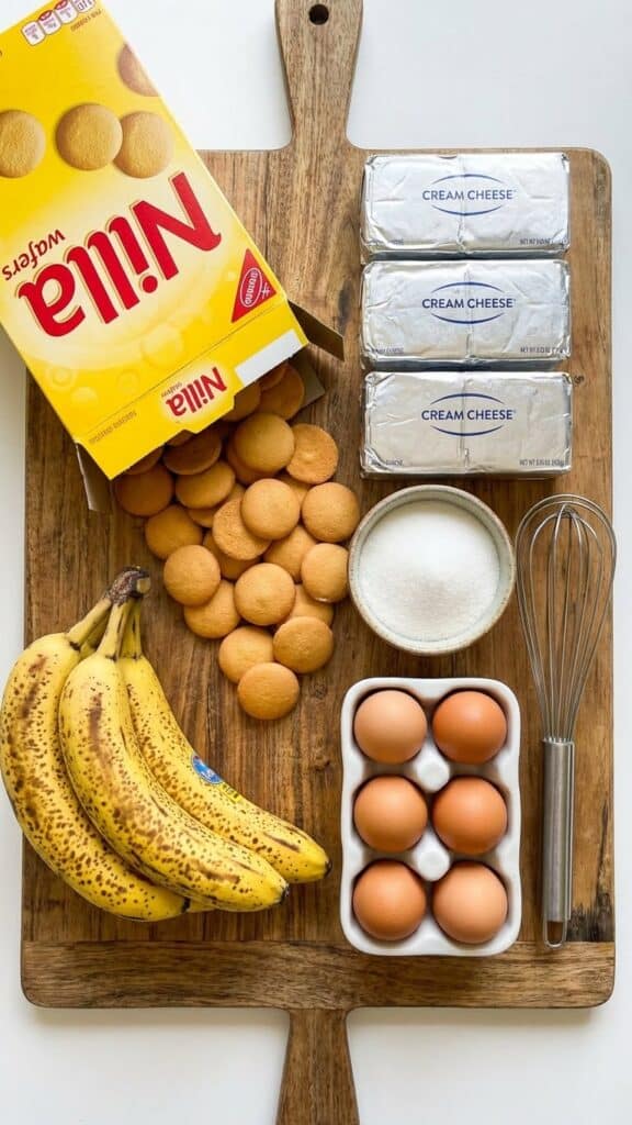 A slice of cheesecake with a Nilla wafer crust on a plate, with a fork taking a bite.
