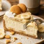 Overhead flat lay of baking ingredients including Nilla Wafers, ripe bananas, cream cheese, and eggs on a wooden board.