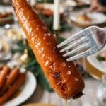 A close-up POV shot of a fork piercing a soft, glazed roasted carrot.