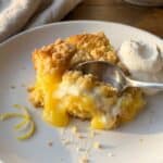 An overhead flat lay of ingredients including a box of yellow cake mix, cans of lemon pie filling, cream cheese, and butter.