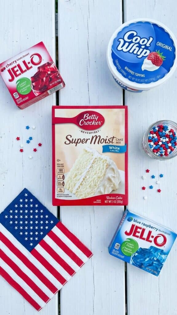 Ingredients for 4th of July cake including white cake mix, red and blue jello boxes, and star sprinkles.