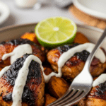 Close-up of a serving bowl filled with roasted BBQ chicken and sweet potatoes.