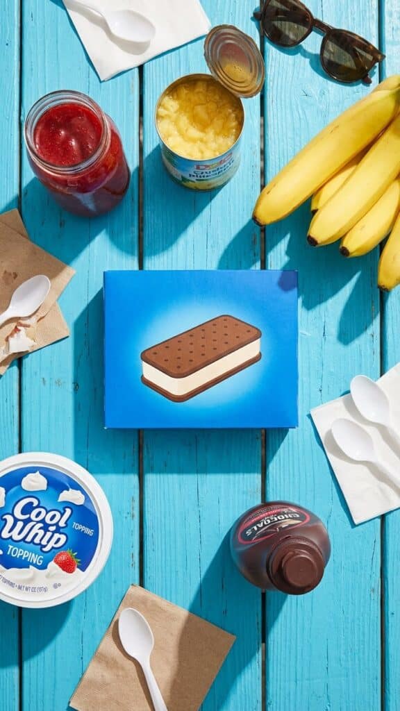 Ingredients for banana split cake including ice cream sandwiches, bananas, and sundae toppings.