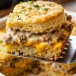 Close-up of a serving of biscuit and gravy casserole showing the hashbrown layer.