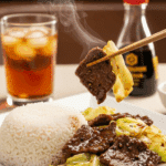 Plated Black Pepper Beef and Cabbage served with jasmine rice and chopsticks