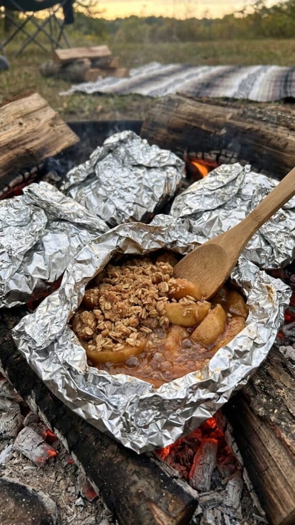 Close-up of a spork taking a bite of warm apple crisp.
