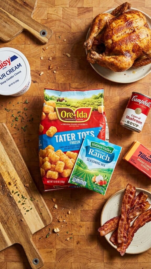 Ingredients for tater tot casserole including frozen tots, ranch packet, rotisserie chicken, and cheese.