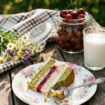 A slice of chocolate banana lush served on a picnic plate with a cherry on top.