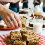 A stack of chocolate peanut butter marshmallow bars served on a checkered napkin.