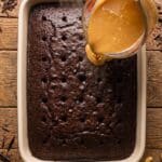 Pouring peanut butter sauce into the holes of a chocolate cake.