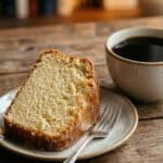 Close-up of a slice of milky pound cake next to coffee.
