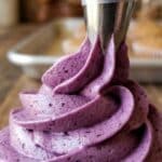 Close-up of blueberry frosting being piped showing texture.