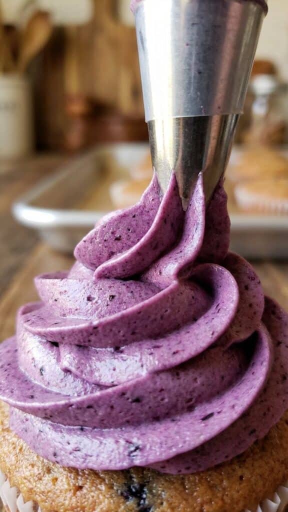 Close-up of blueberry frosting being piped showing texture.