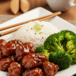 Plated General Tsao's Chicken served with white rice and steamed broccoli.