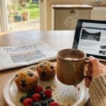 Cinnamon cream cheese muffins served on a breakfast table with coffee and berries.