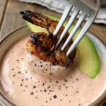 Close-up of grilled shrimp and avocado dipped in pink Louie dressing.