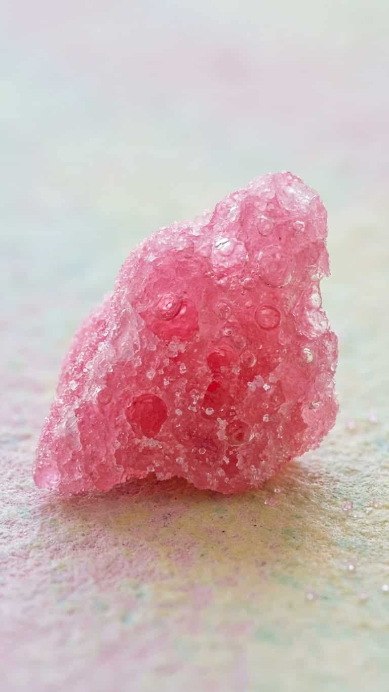 A pile of bright pink homemade fizzy pop rocks candy pieces.