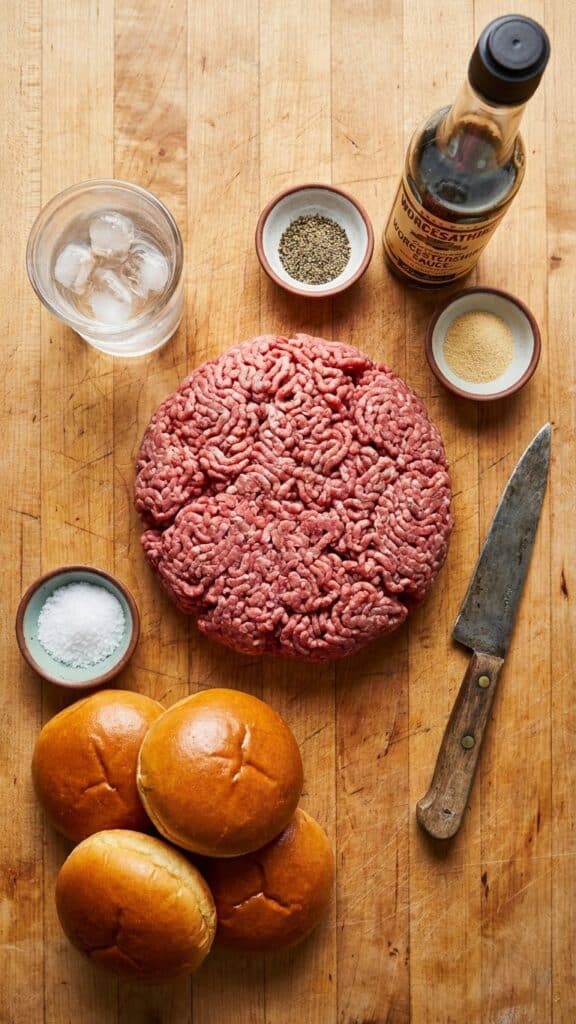 Ingredients for hamburgers including ground beef, ice water, worcestershire sauce, and brioche buns.