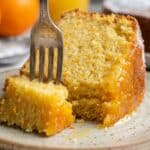 Close-up of a slice of orange juice cake showing the moist, syrup-soaked crumb.