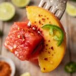 Close-up of a fork with chili-lime seasoned watermelon and peach.