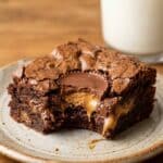 Close-up of a bitten Reese's brownie showing the soft peanut butter cup inside.