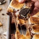 Close-up of a s'mores brownie being pulled apart with stretchy melted marshmallow.