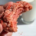 Close-up of a bitten strawberry crunch cookie showing the soft texture inside.