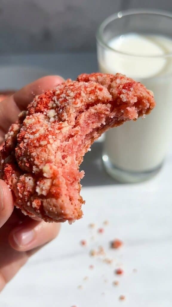 Close-up of a bitten strawberry crunch cookie showing the soft texture inside.