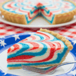 Slice of red, white, and blue marbled pie on a paper plate at a picnic.