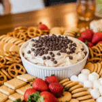 Large dessert platter with brownie batter dip centered amid pretzels, fruit, and cookies.